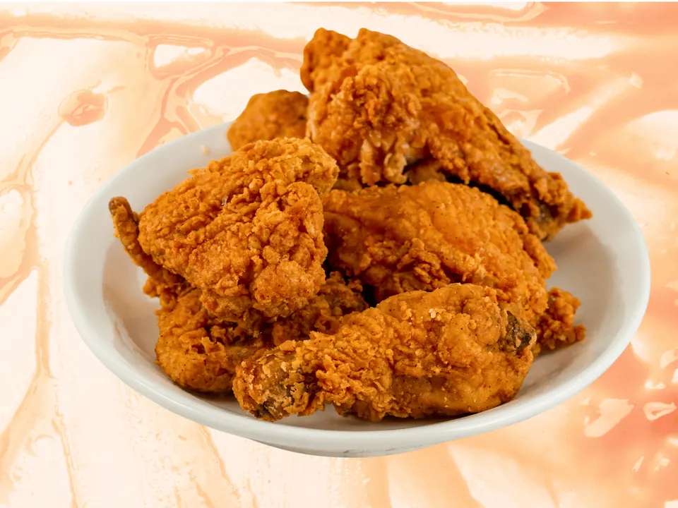 A bowl of golden fried chicken, an 8 piece mix of breasts, wings, thighs and legs