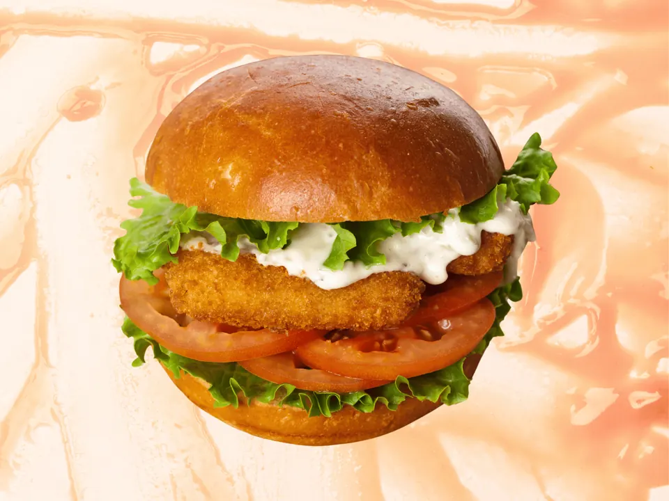 Fried fish sandwich with tartar sauce, lettuce and tomato